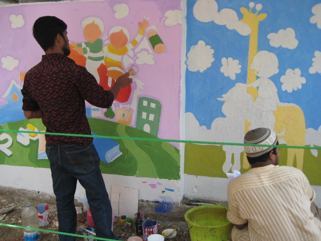 Men painting a mural in Bangladesh